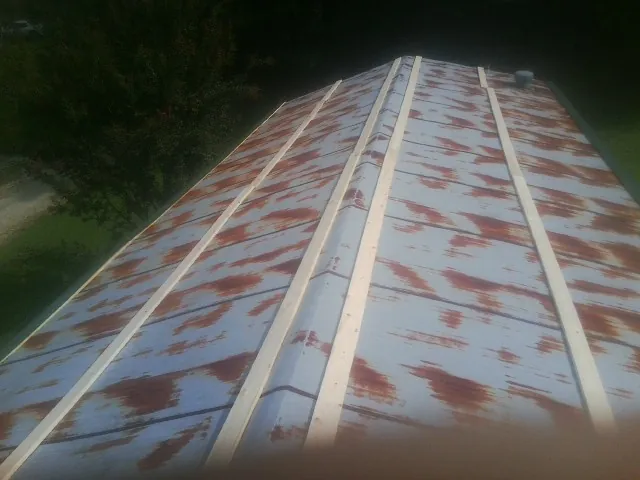 Rusted metal roof panels with new wood purlins before replacement — Storm Damage Roof Repair in Albertville by Roofing Brothers